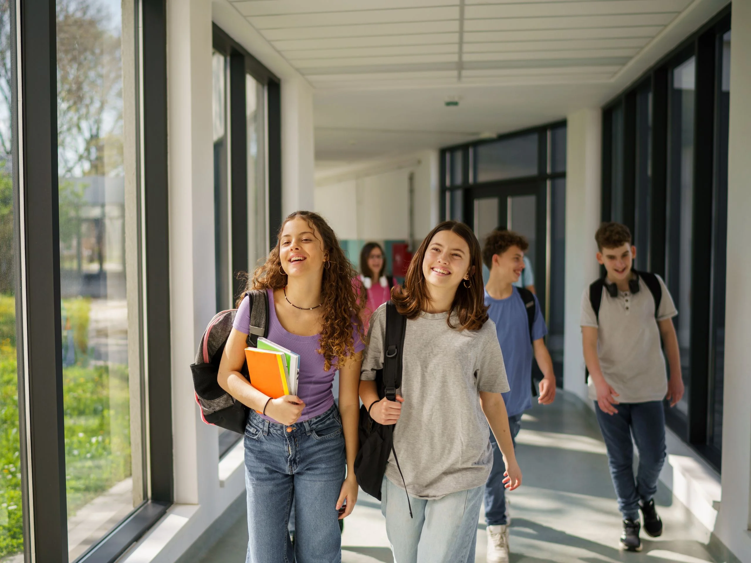Grupo de niños y niñas caminando por el pasillo del colegio