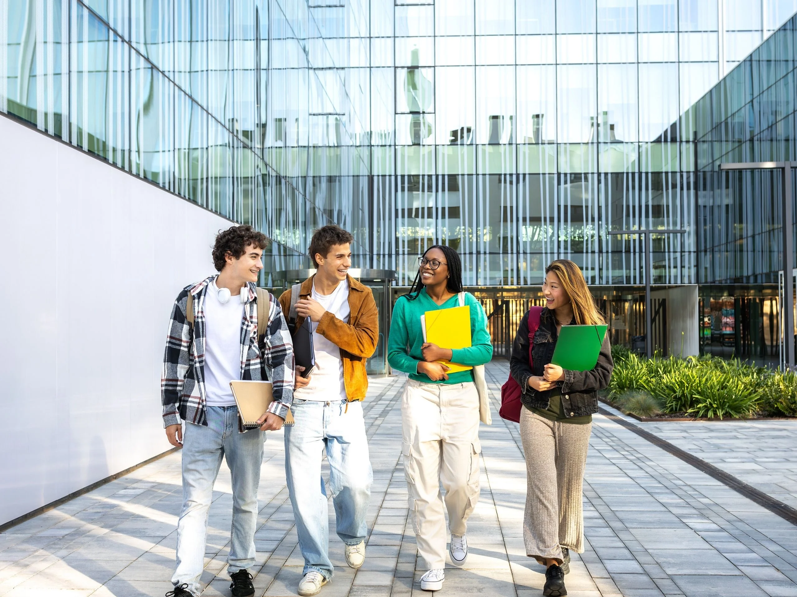 Grupo de estudiantes universitarios caminando y hablando por el campus
