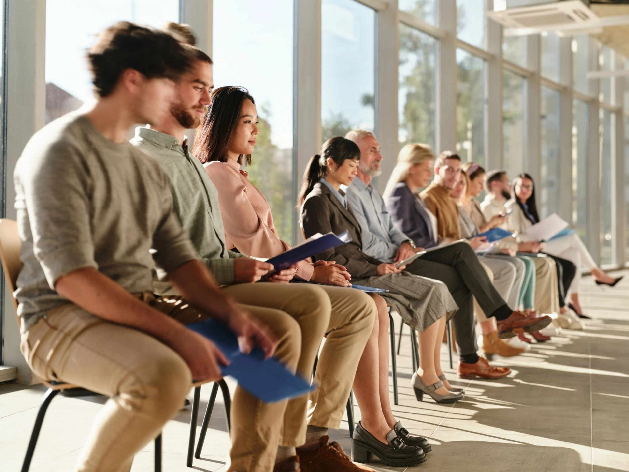 Fila de gente sentada esperando una entrevista de trabajo