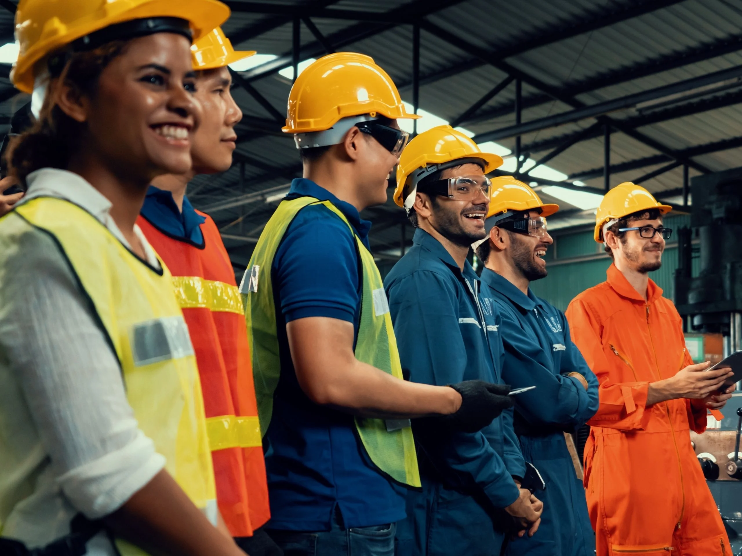 Grupo de trabajadores con chaleco, casco y gafas protectoras