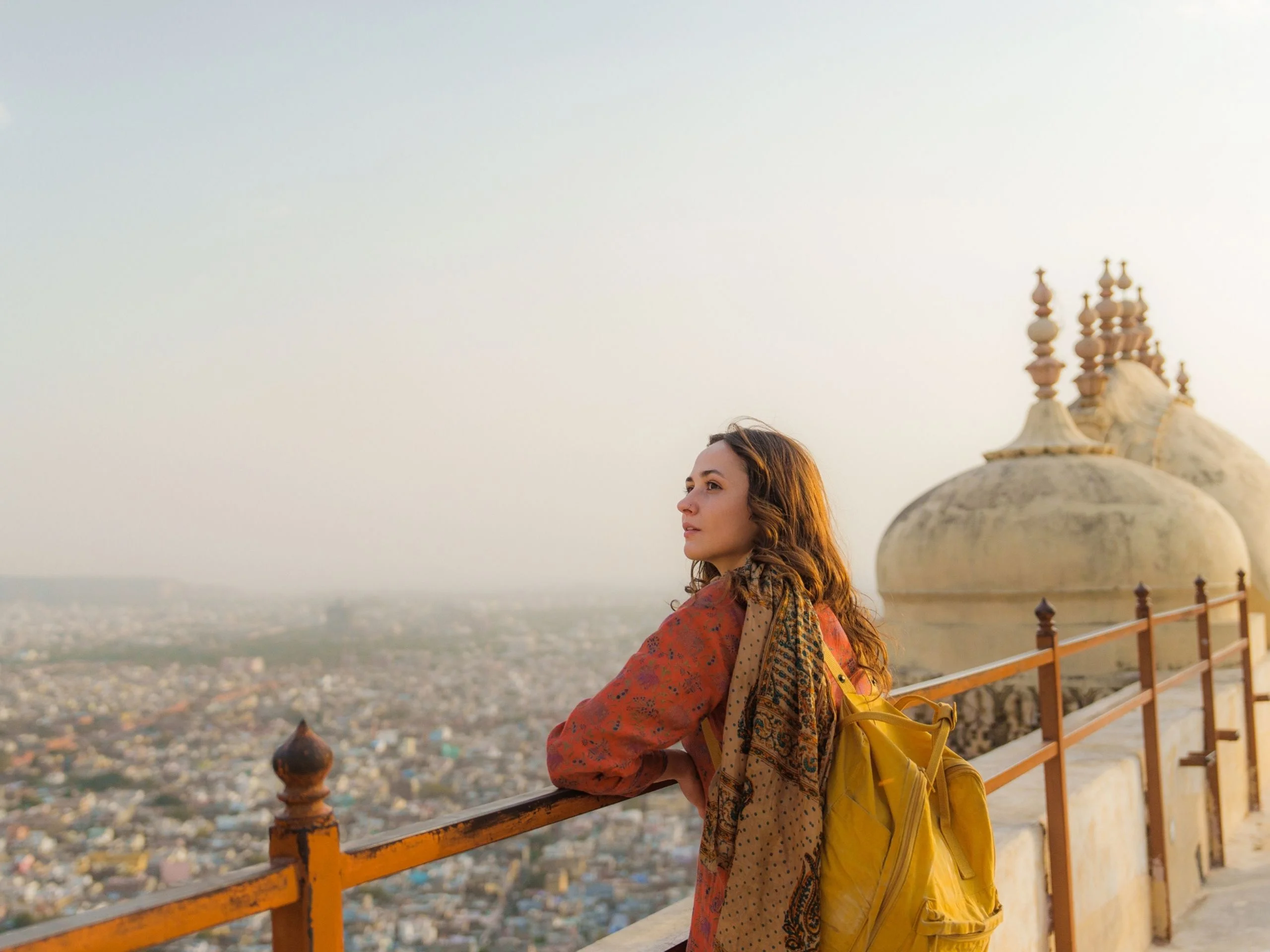 Mujer mirando el paisaje urbano de Jaipur al atardecer