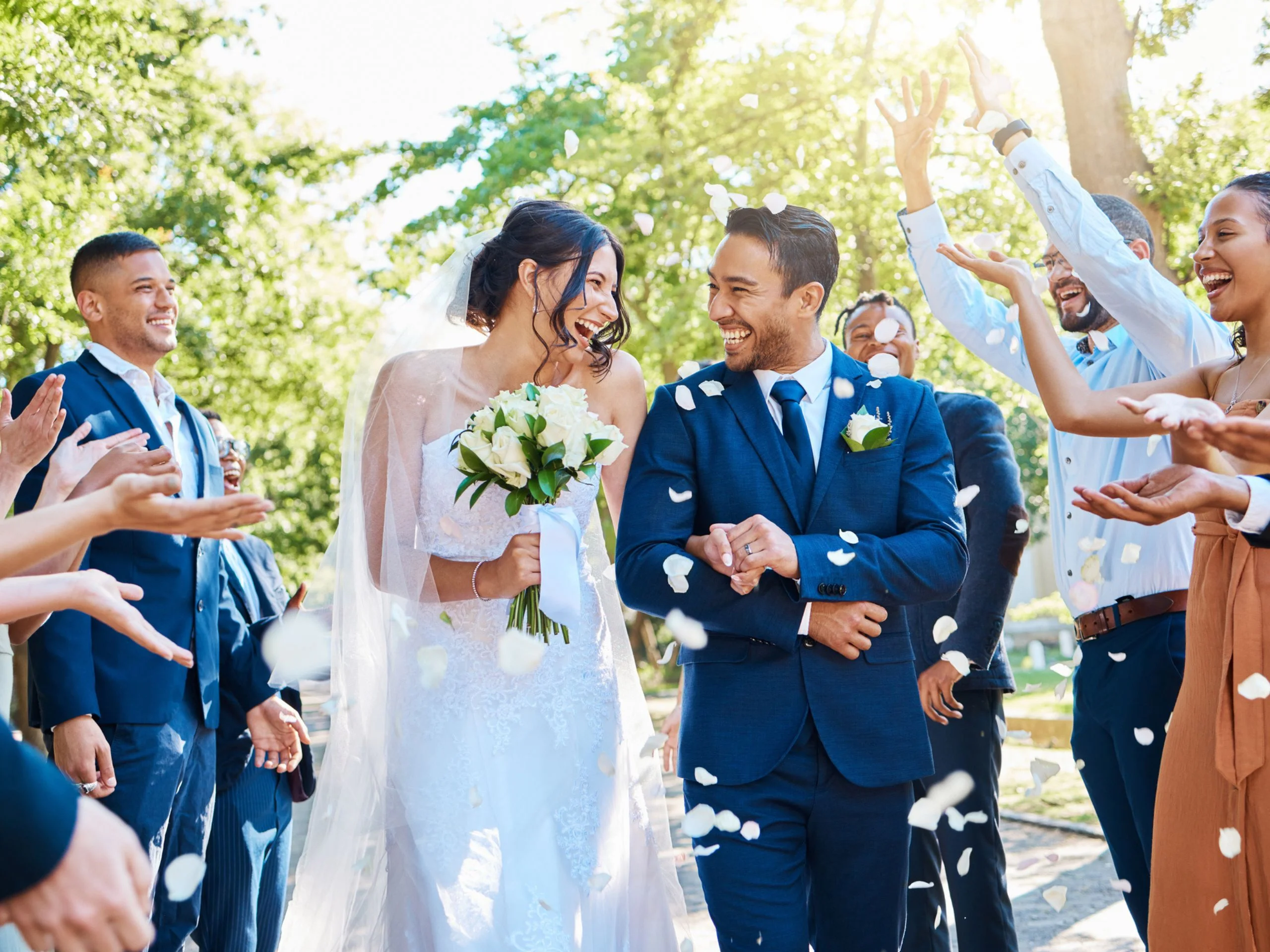 Pareja de recién casados caminando junto a amigos y familiares
