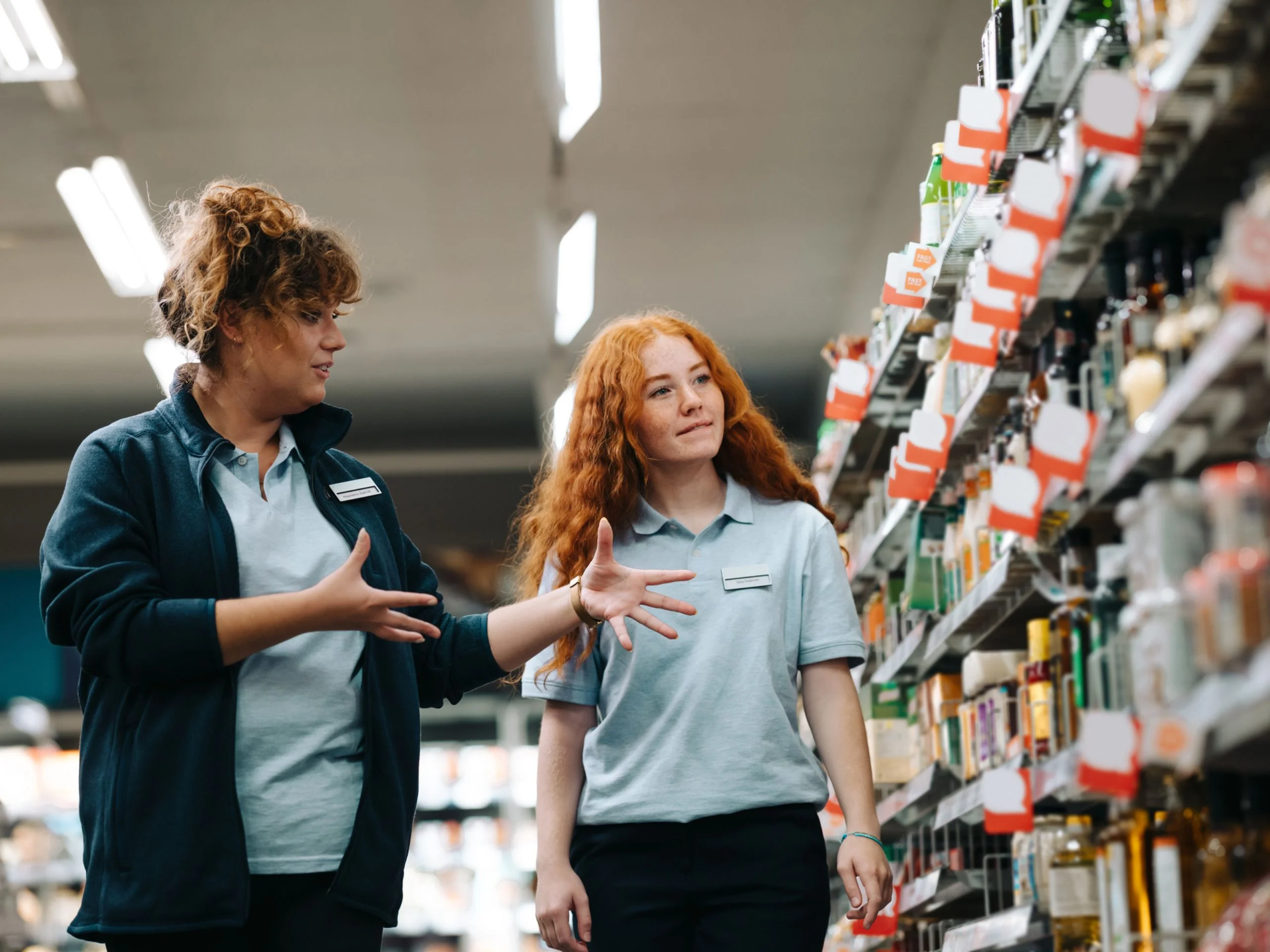 Mujer formando a chica joven en un supermercado