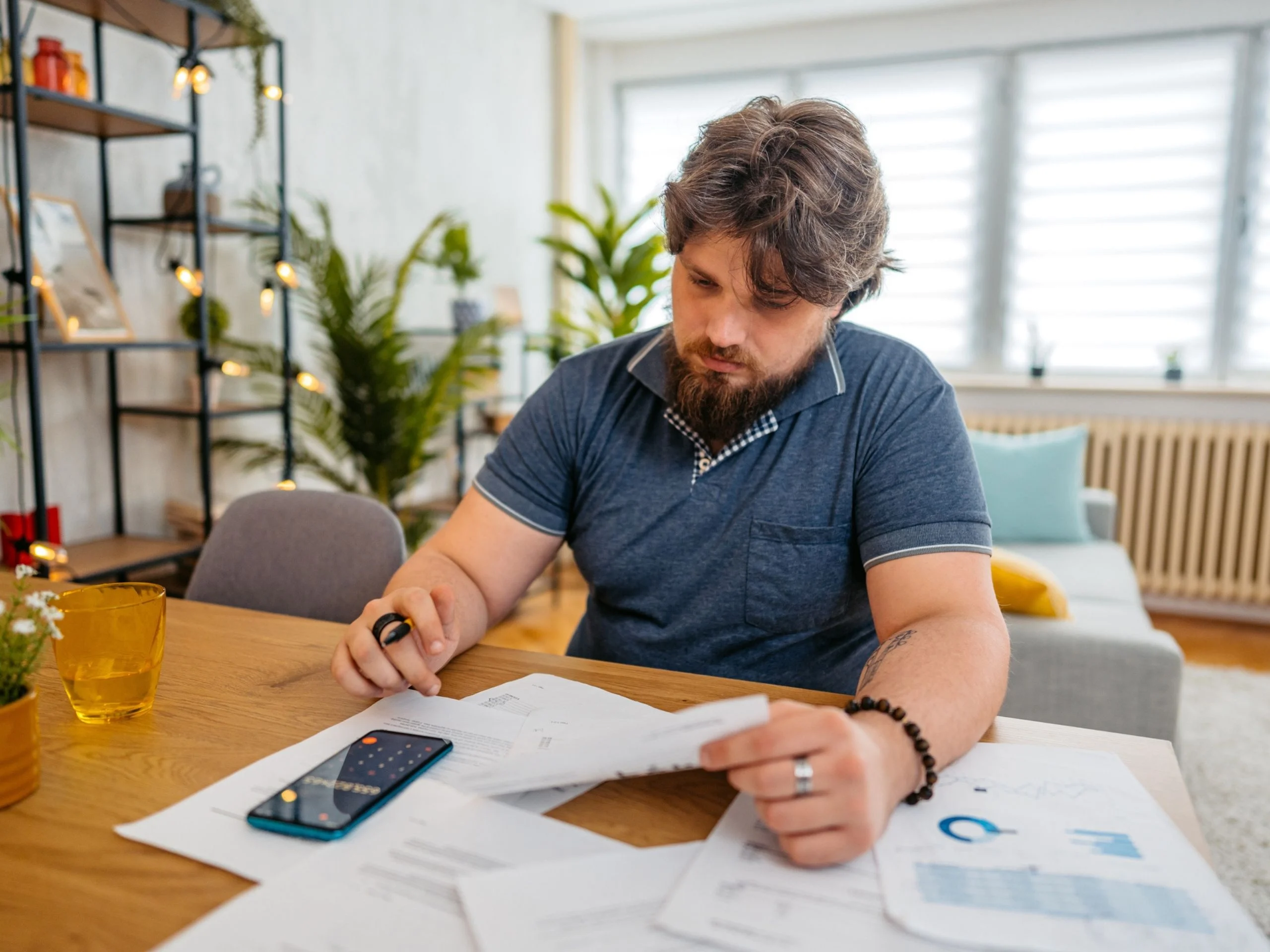 Joven revisando sus finanzas en casa
