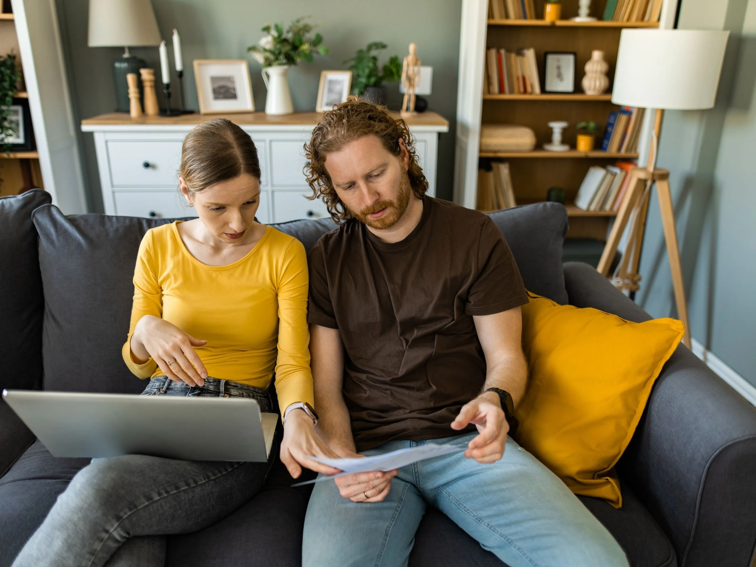 Pareja revisando documentos en el sofá
