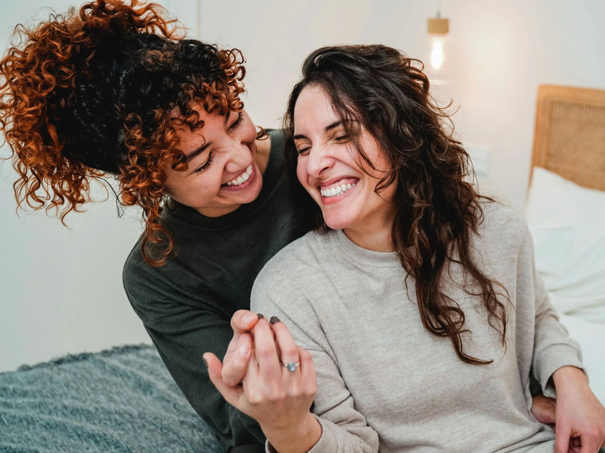 Dos mujeres abrazadas enseñando el anillo de compromiso