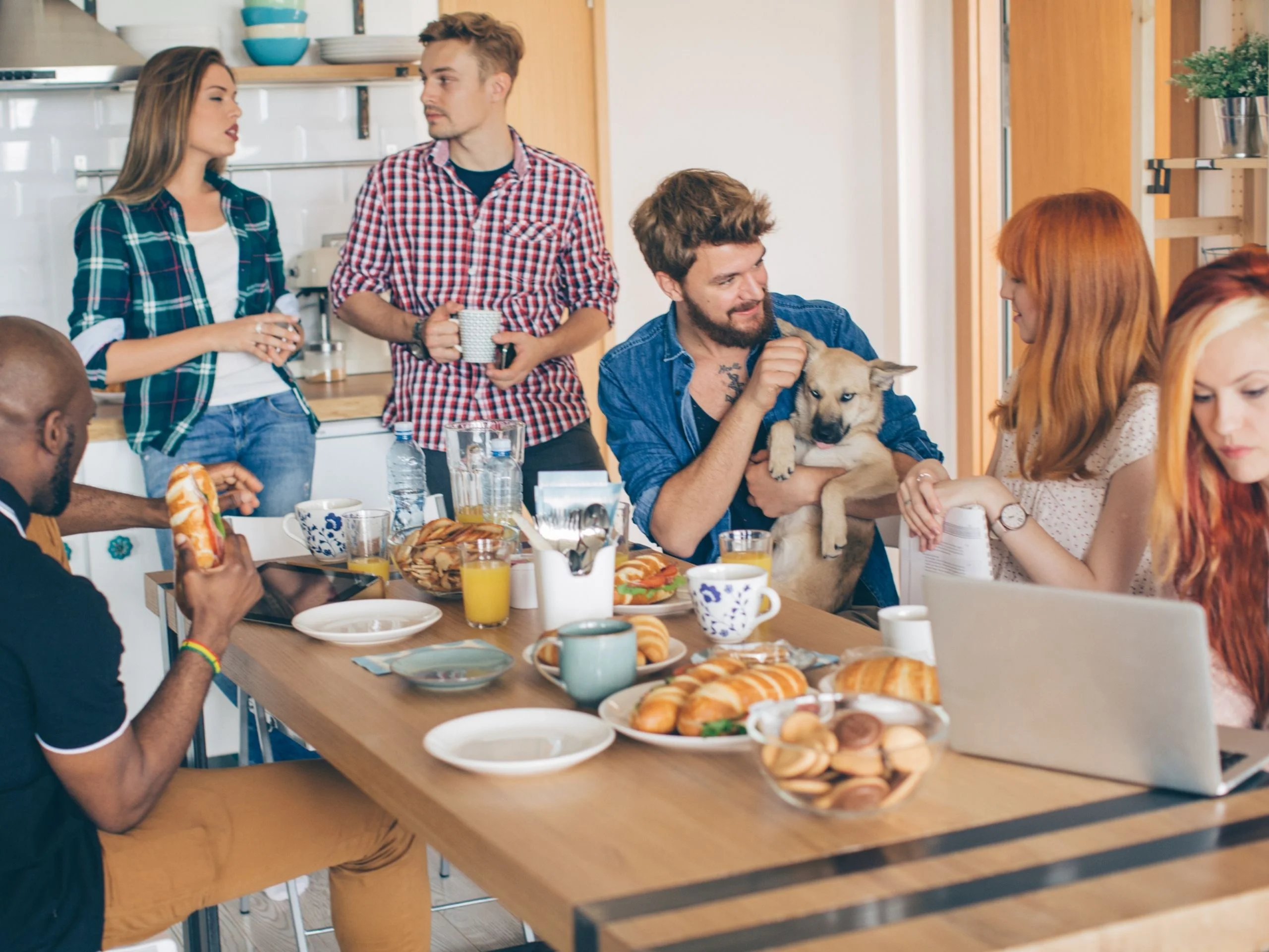 Grupo de compañeros de piso alrededor de la mesa de la cocina