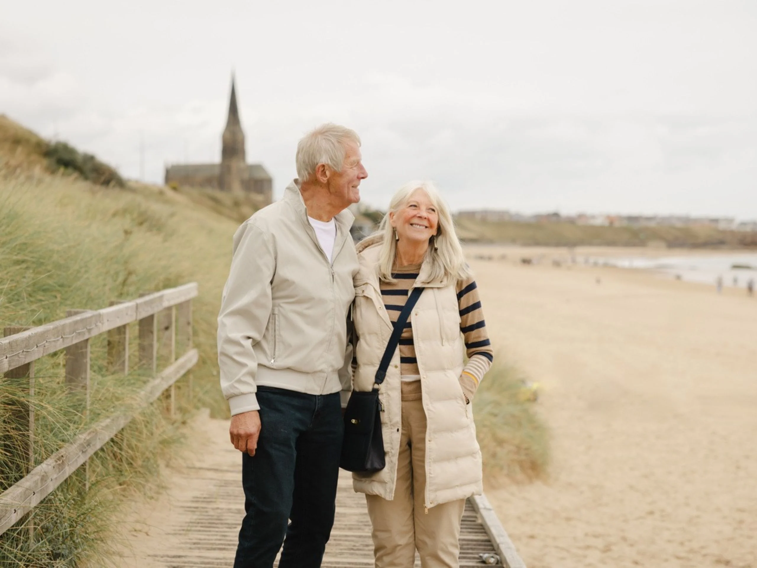 Pareja de jubilados disfrutando de un paseo por la playa