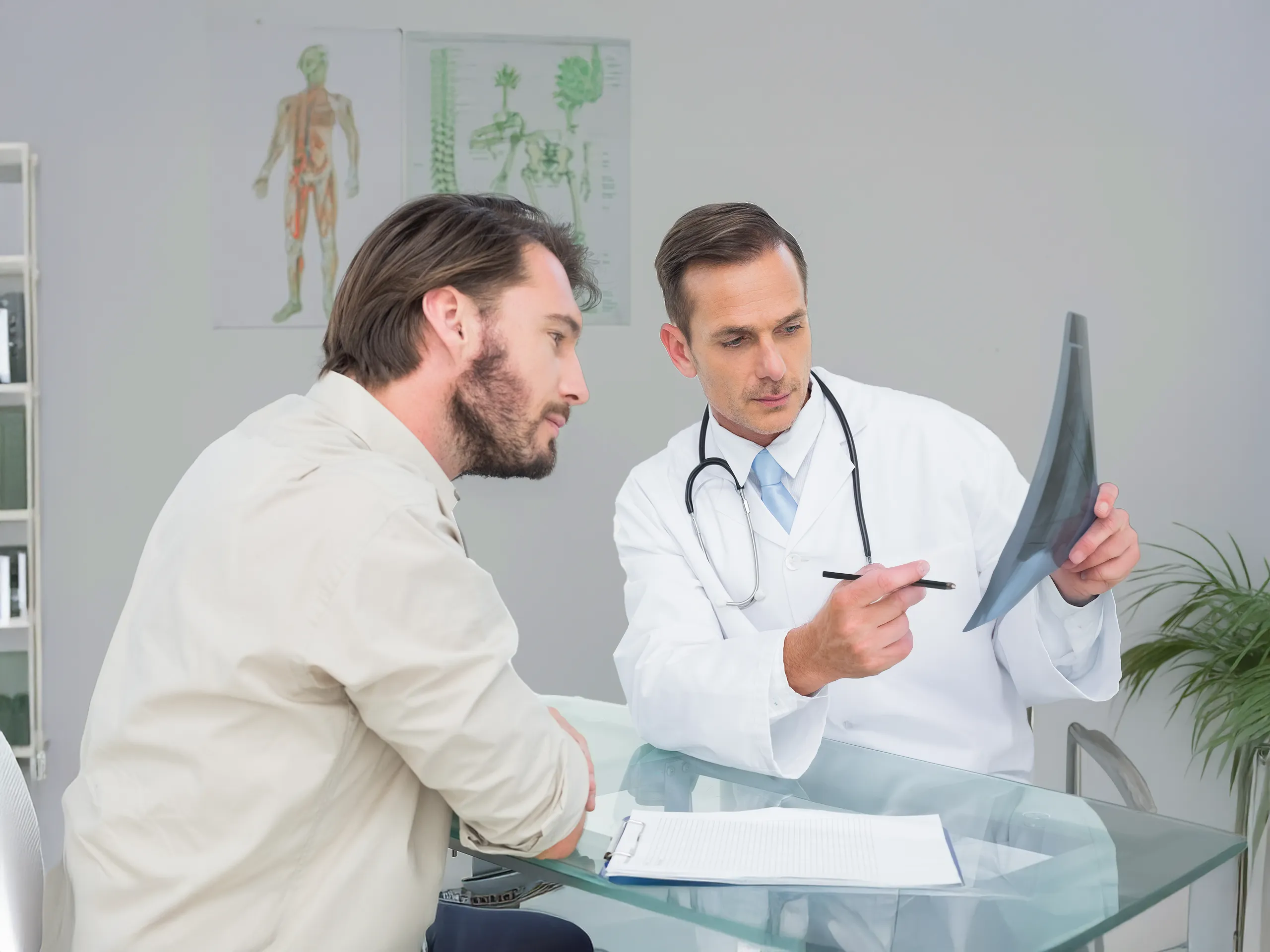 Un médico le explica una radiografía a un paciente varón.