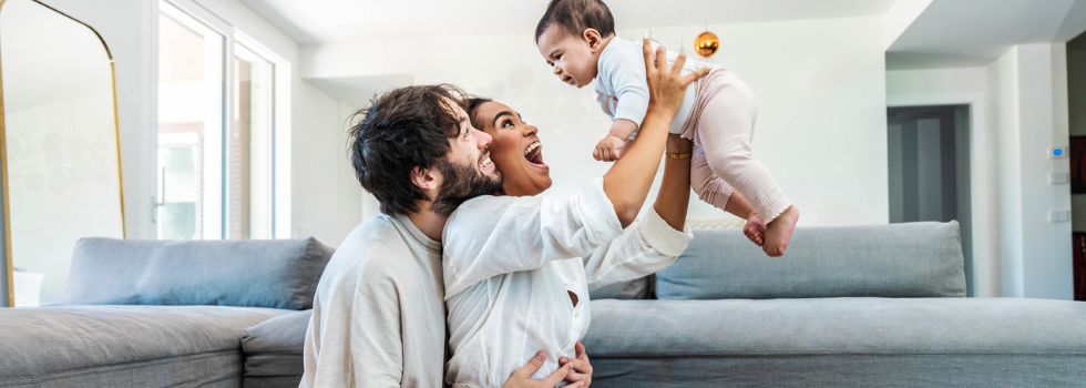 Padre y madre multirraciales jugando con hija pequeña en casa
