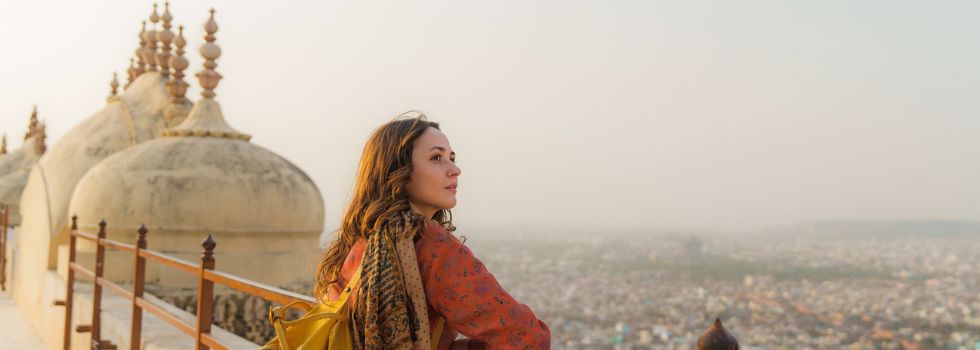 ¿Cuáles son los requisitos para viajar a la India? Mujer blanca admirando paisaje en un mirador en la India