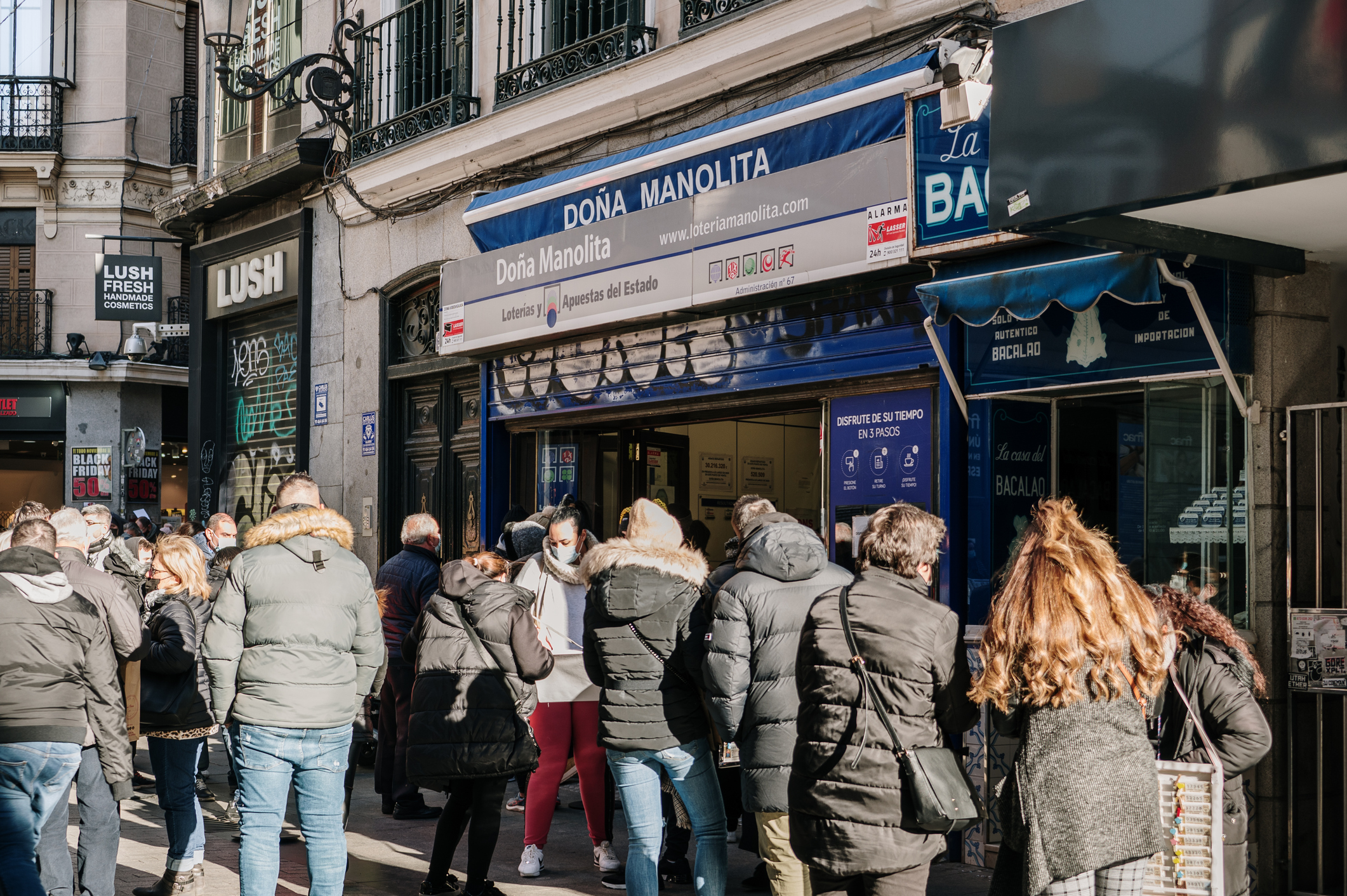 Personas hacen cola ante un administración de lotería